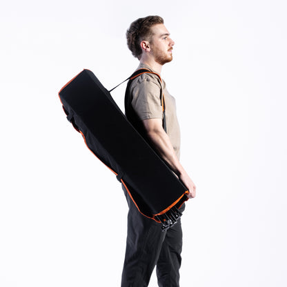 The Bug Beater 2.0, folded up and being carried by a man using its attached backpack strap, against a white background.